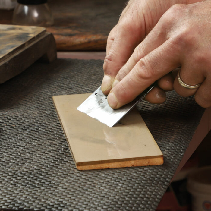 Polish the bevel. Holding the blade so its bevel is flat on the sharpening stone, hone the bevel with a few strokes.